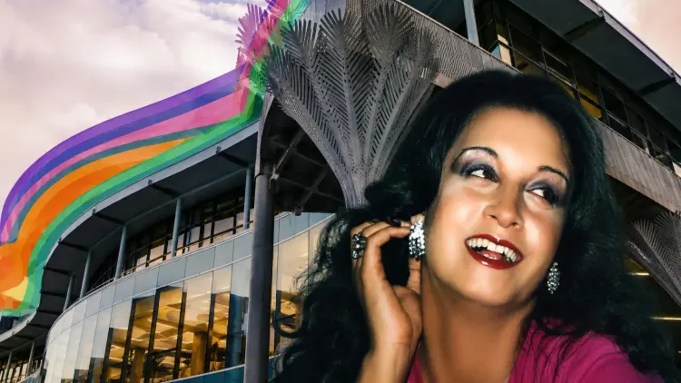 Transgender woman Georgina Beyer in front of rainbow coloured Wellington Central Library building