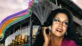 Transgender woman Georgina Beyer in front of rainbow coloured Wellington Central Library building