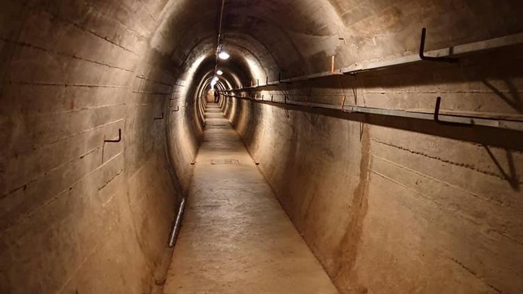 Photo of the inside of one of the tunnels in Wrights Hill Fortress which is lit up by lights hanging from the top of the tunnel