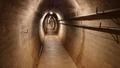 Photo of the inside of one of the tunnels in Wrights Hill Fortress which is lit up by lights hanging from the top of the tunnel