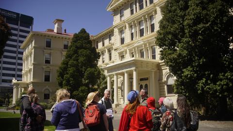 A group of walk tour participants gathering outside Old Government Buildings, as part of the ‘A Change is Coming’ walk tour in 2025.