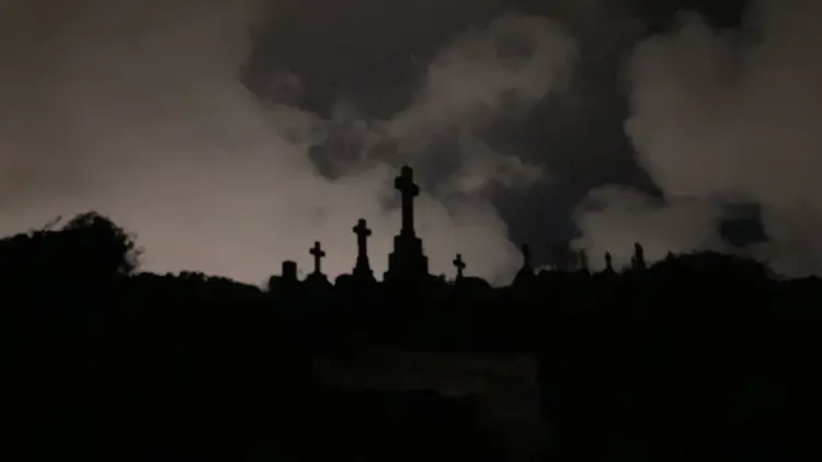 Tombstones of crosses in a background of clouds at dusk