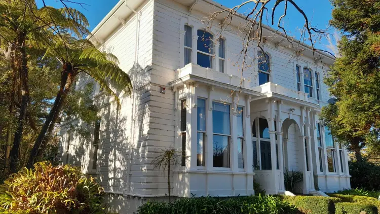 White colonial house surrounded by trees