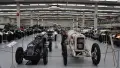 A large warehouse full of cards of various ages, backed by three aeroplanes.