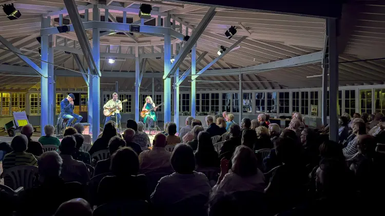 Three muscians playing on a stage in front of an audience