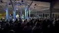 Three muscians playing on a stage in front of an audience