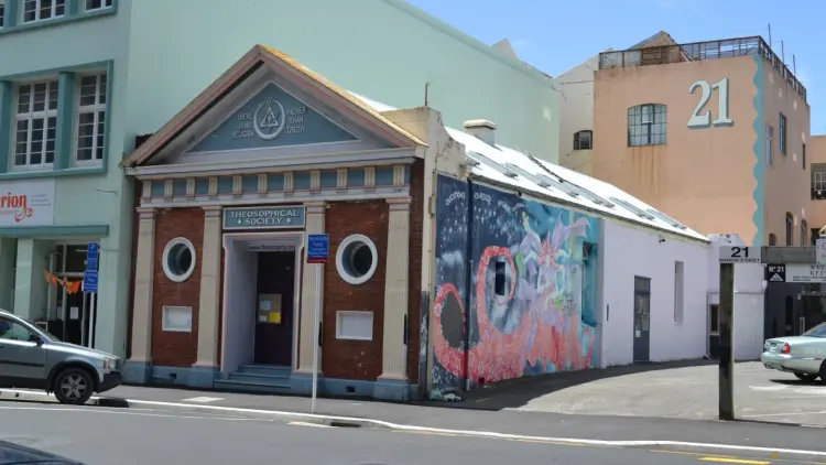 Exterior shot of small brick building with a triangular roof