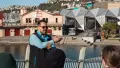 Man presenting to a group in front of lagoon and buildings
