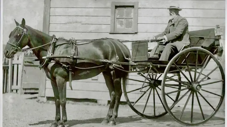Sepia photograph of a man in a horse drawn cart