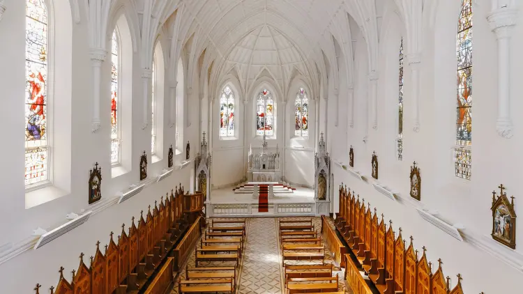 Interior of a white walled church with pews