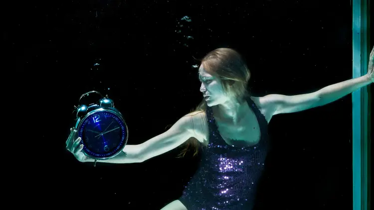 Woman in purple leotard holding a clock with a blue face