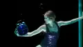 Woman in purple leotard holding a clock with a blue face