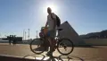 Outdoors hoft of a man standing by a bicycle