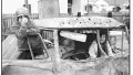 Black and white photograph of two children inside an old car