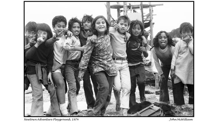 A group of children look at the camera from an adventure playground