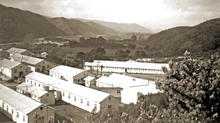 Sepia photograph of buildings surrounded by hills