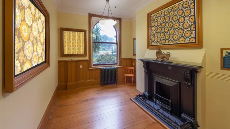 Wooden hallway with paintings, a window and a fireplace