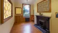 Wooden hallway with paintings, a window and a fireplace