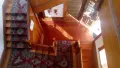 Looking down on a native timber staircase with a red rug