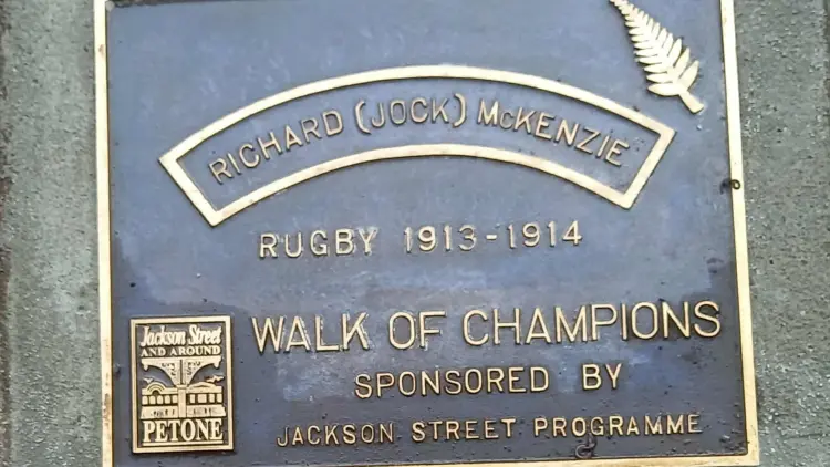 Black and gold headstone for Walk of Champions, silver fern icon on top right