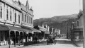 Black and white photo of a stree with a vintage car