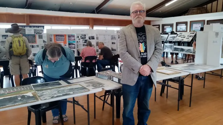 Man standing in front of tables with historical information laid out