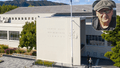 Large grey building with additional photo of man in cap in the top corner