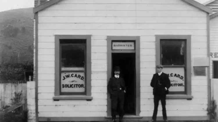 Historic photo of two people outside a store