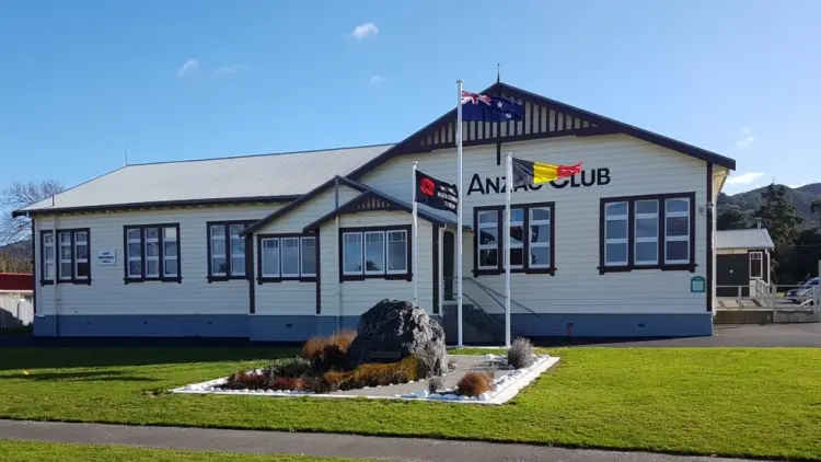 Exterior shot of historic building with flags out front. Building reads ANZAC CLUB