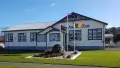 Exterior shot of historic building with flags out front. Building reads ANZAC CLUB