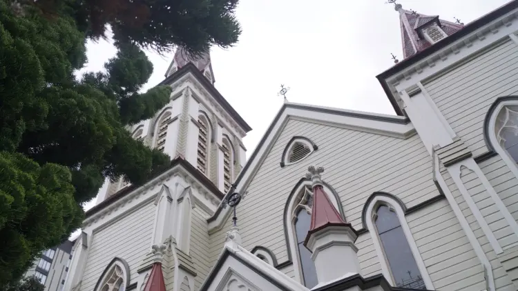 Exterior shot of large white and cream church with red roof