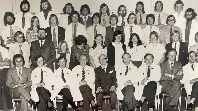 Black and white photograph people people sitting in staggered rows