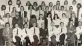 Black and white photograph people people sitting in staggered rows