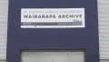 Photograph of the front of a navy and grey building with a sign for the Wairarapa Archive above the glass doors