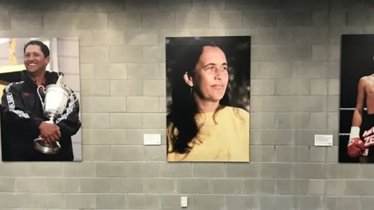 Three photographs of people mounted on a wall