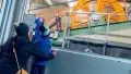 Child and adult standing in front of a winding mechanism