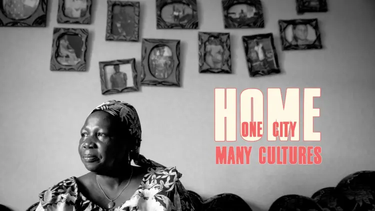 Black and white photo of a woman with framed photographs on the wall