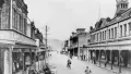 Black and white photograph of an old street with people on bicycles