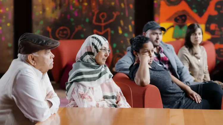 Image of people in a colourful room looking forward