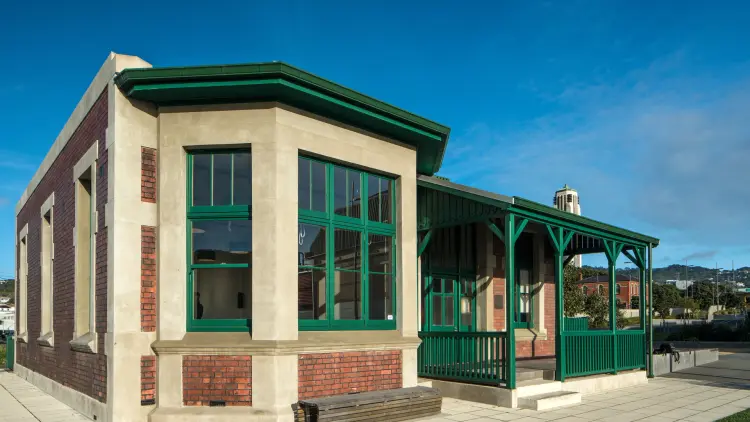 A photo of the Pukeahu Education Centre building, brick and beige cladding with emerald green window frames.
