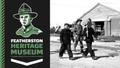 Banner reading Featherston Heritage Museum. Photo of prisoners of war being escorted by a soldier to the right.