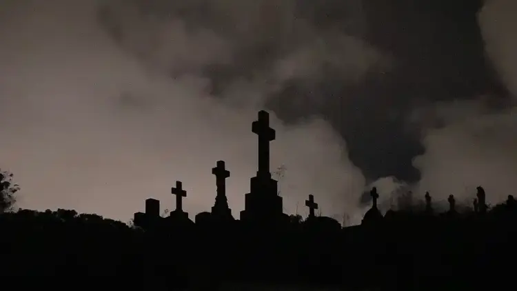Tombstones of crosses, white clouds in a dark sky