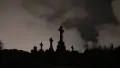 Tombstones of crosses, white clouds in a dark sky