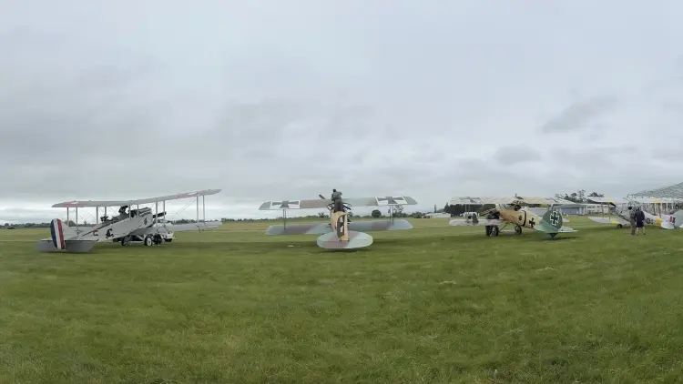 Four historic world war one planes line up on a grassy field