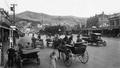 1920s photo of vintage cars and carts with horses along Courtney Place