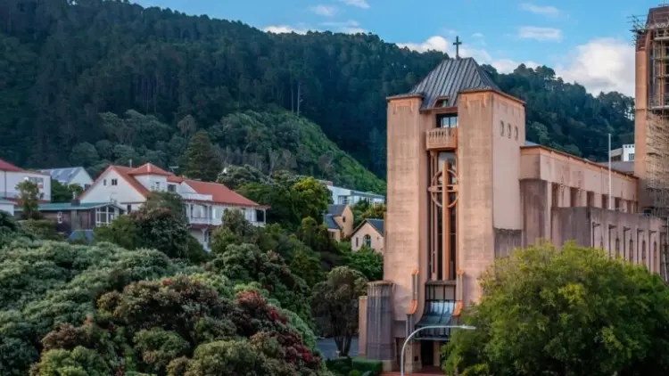 Exterior shot of large pink cathedral surrounded by trees