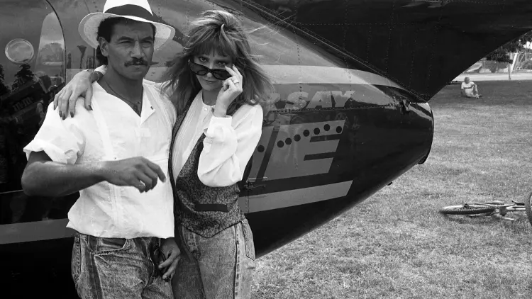 A man and woman standing in front of a plane
