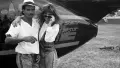 A man and woman standing in front of a plane