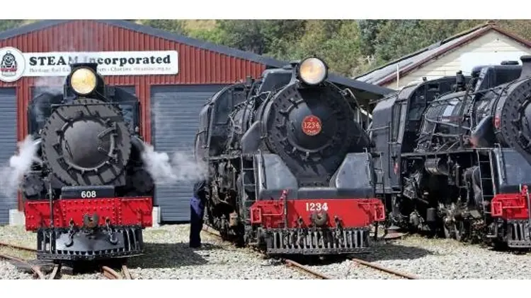 Three black and red steam trains