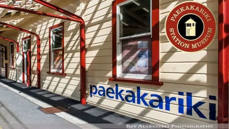 Paekakariki station painted yellow and red, logo for Paekakariki Station Museum on the top right